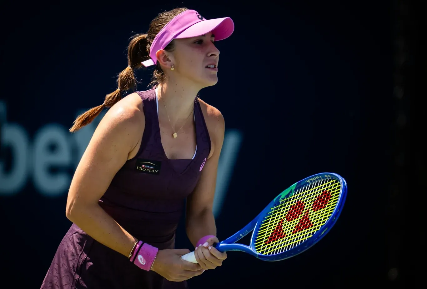 Belinda Bencic w sportowym stroju i różowej czapce przygotowuje się do odbioru serwisu na korcie tenisowym